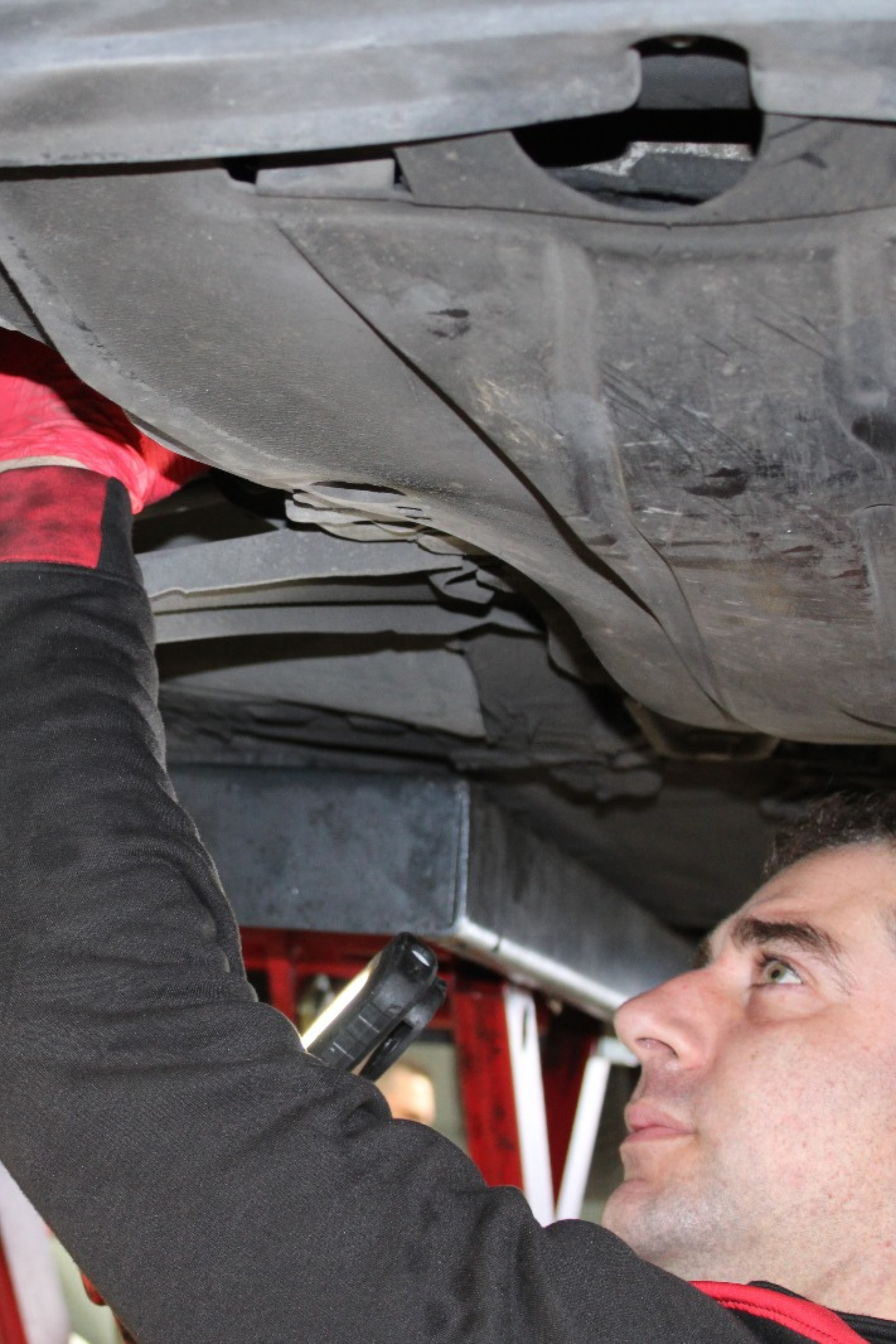 Trabajador-de-Bugauto-reparando-bajos-coche